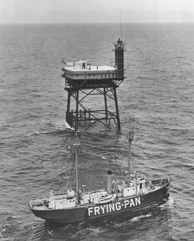 Aerial photograph, 1965: the new steel light station stands on four splayed legs above the ocean while the lightship FRYING-PAN, its name painted large on the hull, rides at anchor below it.